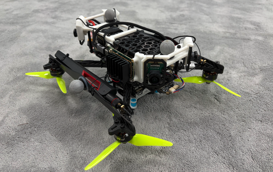 The assembled quadcopter. White 3D-printed parts hold the four fisheye cameras and protect the onboard compute.